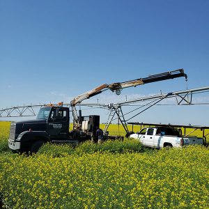 Western Water Management Service Truck Performing Irrigation Maintenance in a Field in Saskatchewan, Canada