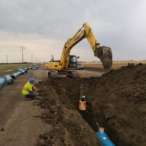 Two workers Trenching for Western Water Management